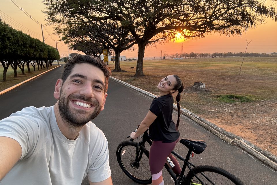 As bicicletas paradas na estrada, com o sol se pondo atrás das árvores