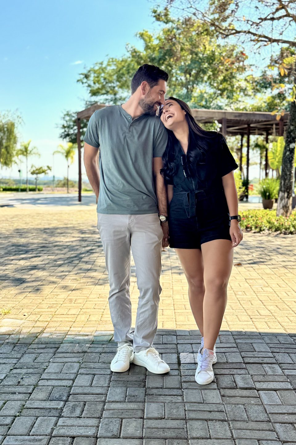O casal rindo, caminhando num calçadão