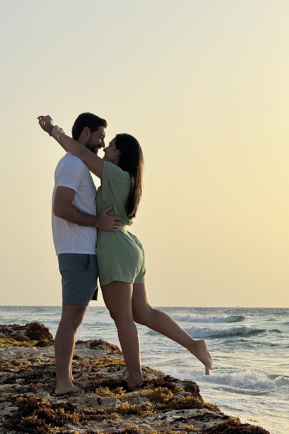 Os dois dançando sobre as pedras, à beira do mar