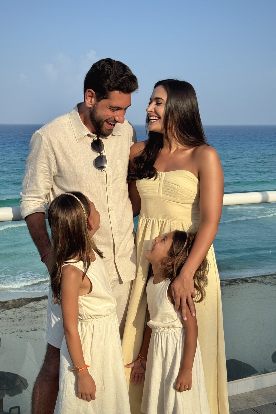 Ana e Renan com a Soso e a Lizzie, os quatro rindo juntos diante do mar