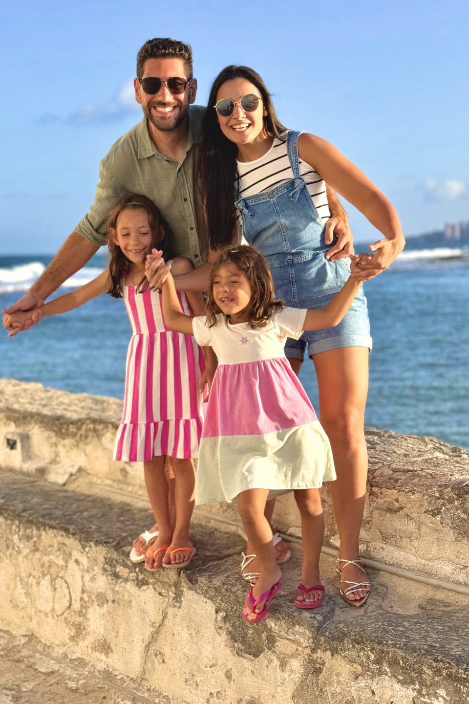 O casal com a Sophia e a Lizzie à beira do mar