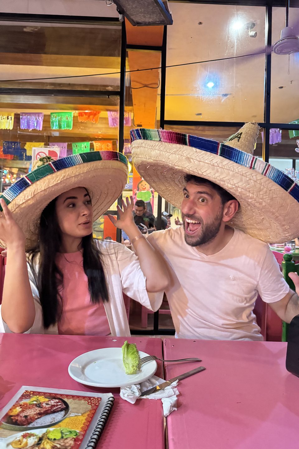 Os dois de sombrero, à mesa de um restaurante mexicano