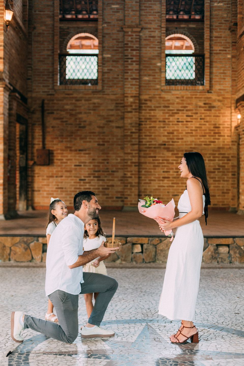 Renan de joelhos, com um buquê nas mãos, pedindo Ana em casamento