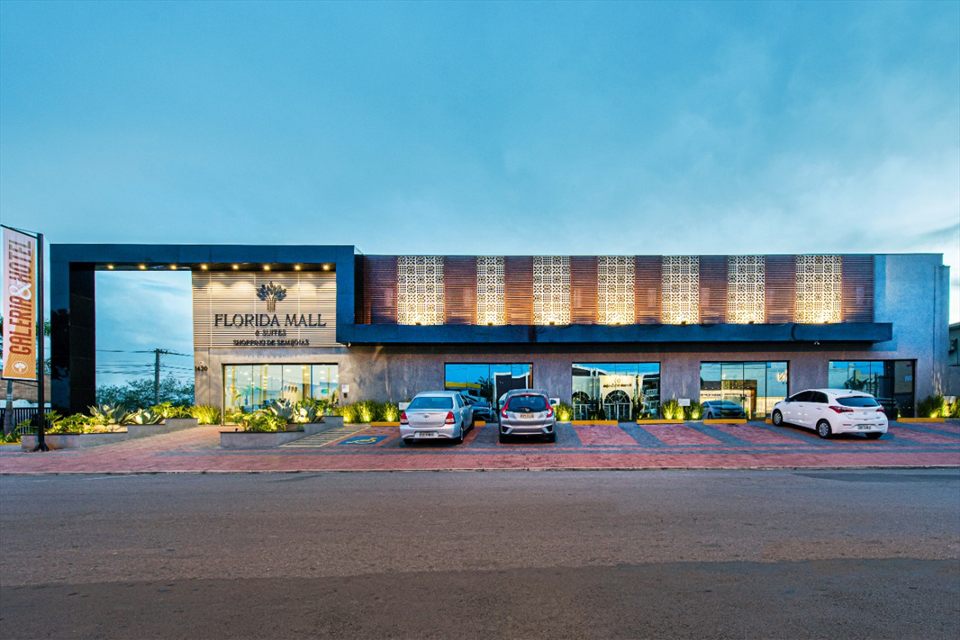A fachada do Florida Mall & Suites ao anoitecer, com o letreiro sobre a entrada