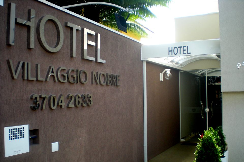 A entrada do Hotel Villaggio Nobre, com o nome em letras de metal no muro