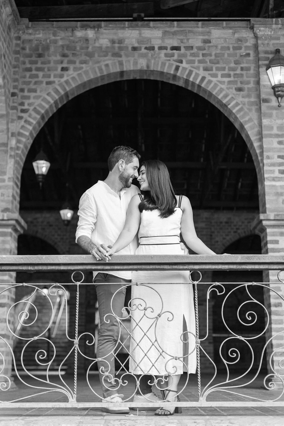 Retrato em preto e branco do casal na sacada de ferro