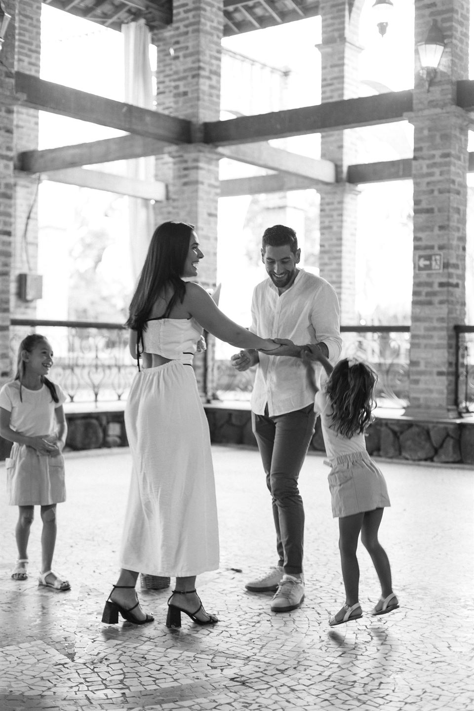O casal dançando com as meninas, em preto e branco